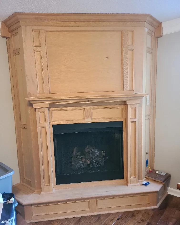 Custom built fireplace mantel and surround in raw wood before finishing