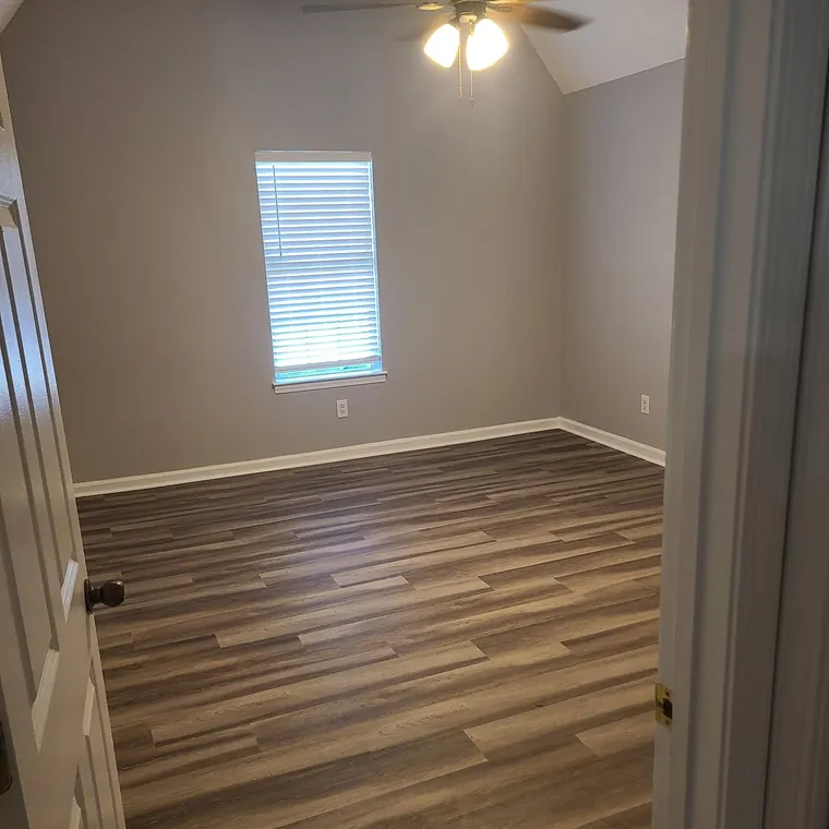 Vinyl plank flooring running through a renovated hallway and bedroom