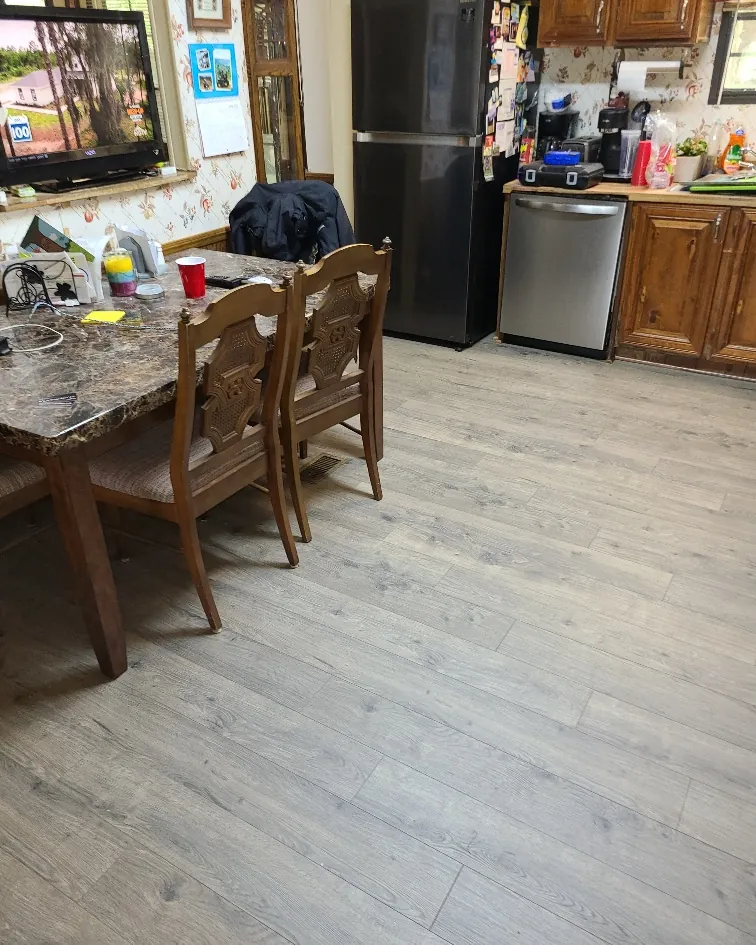 New plank flooring through an open dining and kitchen area