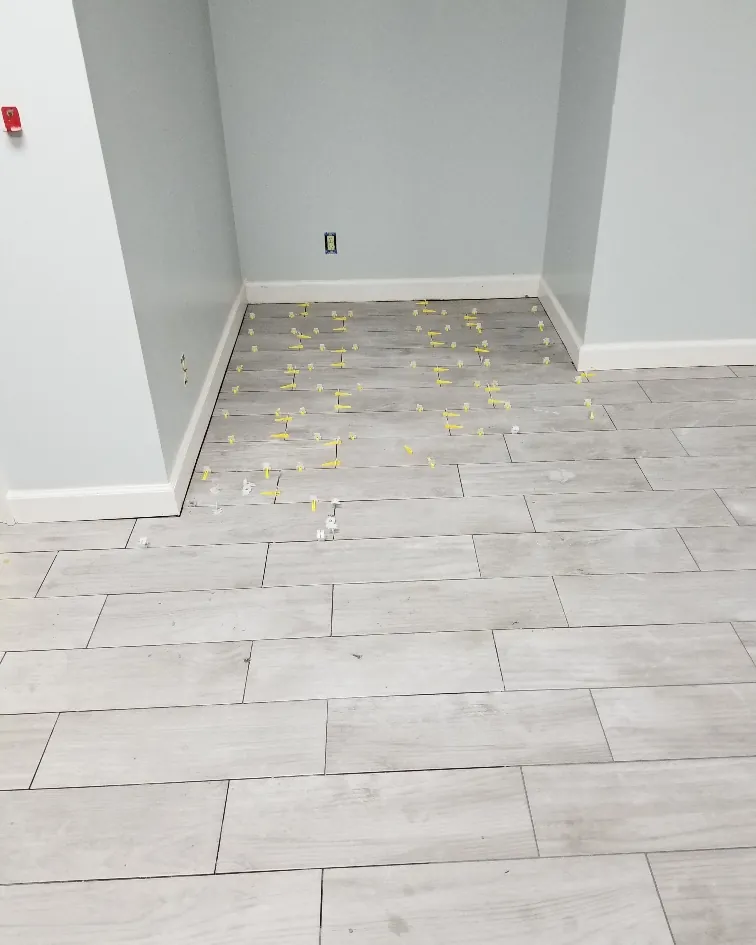 Wood-look plank tile being set with spacers over a prepped subfloor