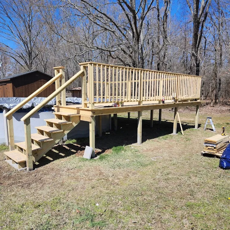 Custom deck build with stairs and railing on a sloped back yard