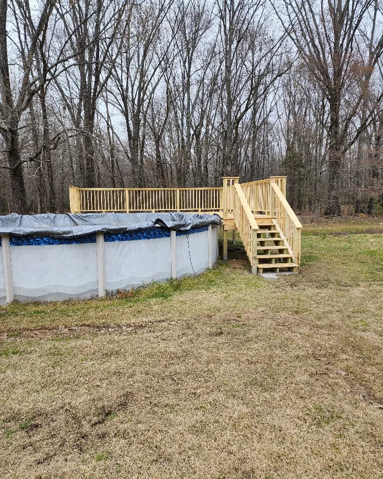 Pool deck with stairs and railing built in a back yard