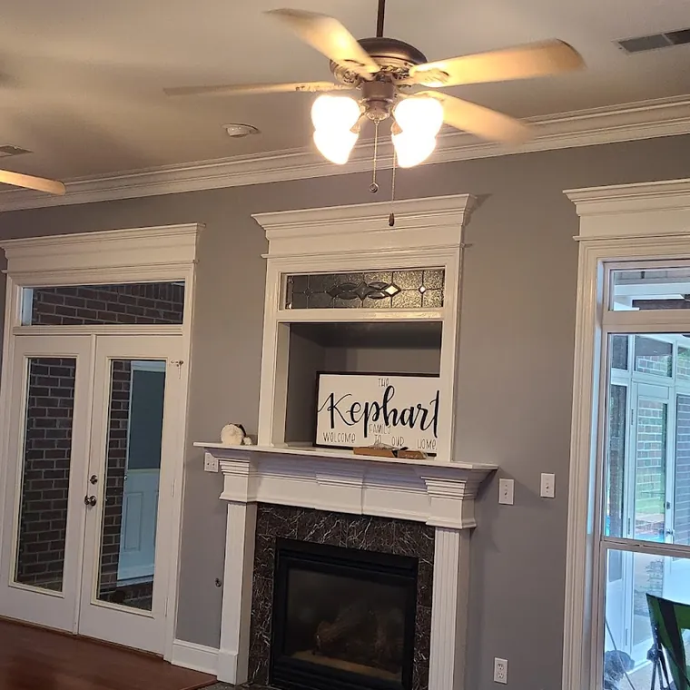 Renovated living room with a custom fireplace mantel, crown molding and refinished hardwood floors