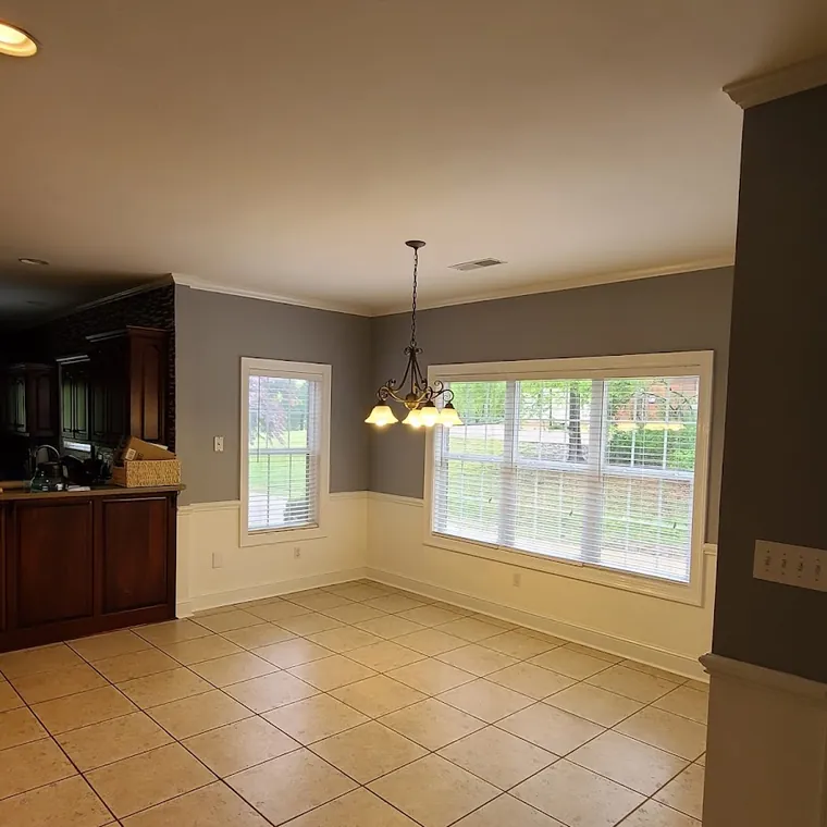 Open kitchen and dining area with tile flooring and new lighting after a remodel