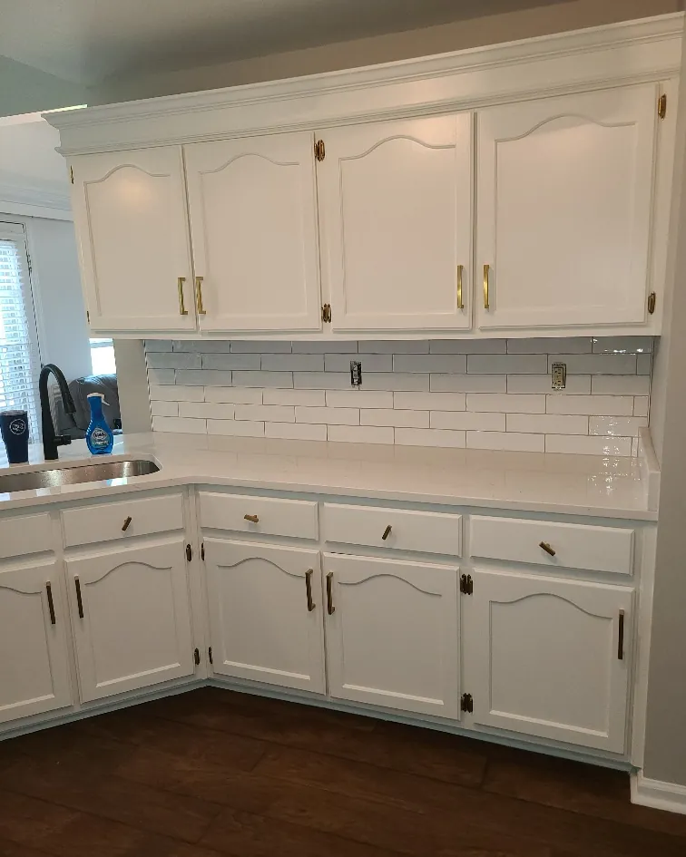 Kitchen with painted cathedral-arch cabinets, subway tile backsplash and quartz counters