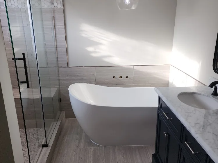 Bathroom remodel with a freestanding soaking tub, frameless glass shower and a dark double vanity