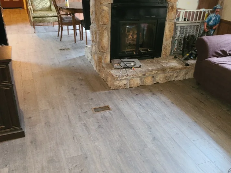 Living area with a floor-to-ceiling stone fireplace and new luxury vinyl plank flooring