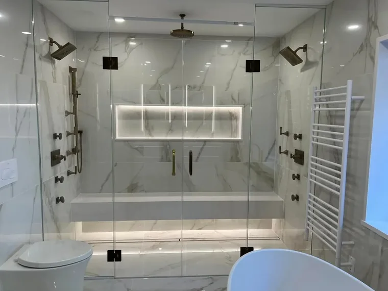 Marble tile walk-in shower with a built-in niche and frameless glass door